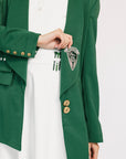 Green blazer with gold buttons and a badge on a white background