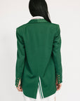 Green blazer worn by a person on a white background