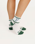 White socks featuring green and blue text on a white background