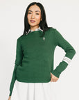 Woman wearing a green Dorothy sweater with a white collar against a white background
