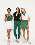 Three women wearing green and white outfits on a white background