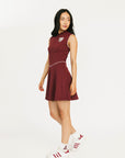 Woman wearing a maroon dress with a white logo on a white background