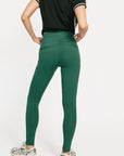 Person wearing green leggings and a black top on a white background