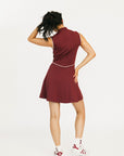 Woman wearing a maroon dress with a white logo on a white background