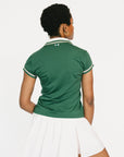 Woman wearing a green polo shirt with white trim on a white background