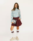 Person wearing a smoke blue Lottie Mock Neck and merlot Eleanor shorts on a plain background