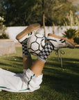 A model wearing the indigo charlie crew socks holding a soccer ball between her legs.