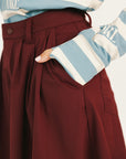 Person wearing a smoke blue Lottie Mock Neck and merlot Eleanor shorts on a plain background