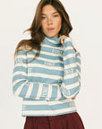 Woman wearing a blue and white striped sweater with 'FORE' text on a plain background