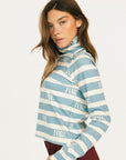 Woman wearing a blue and white striped sweater with 'FORE' text on a plain background