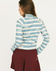 Woman wearing a blue and white striped shirt with 'FORE!' text on a plain background