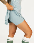 Person wearing a light blue dress with a white background
