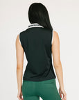 Woman wearing a black sleeveless Moore Polo with white collar and text details on a plain background