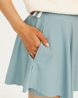 Smoke blue Manhattan skirt worn by a person on a white background