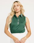 Woman wearing a green sleeveless Moore Polo shirt with white trim on a plain background