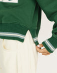 Woman wearing a green sweatshirt with 'FORE' text on a white background