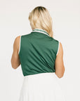 Woman wearing a green sleeveless Moore Polo shirt with white trim on a plain background