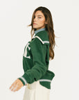 Woman wearing a green sweatshirt with 'FORE' text on a white background