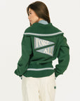 Person wearing a green varsity jacket with 'FORE ALE' text on the back against a white background