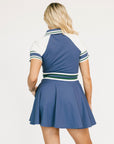 Woman wearing a blue and white dress with striped collar on a white background