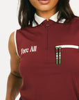 Woman wearing a maroon sleeveless polo shirt and cap with white accents, standing against a plain background.