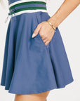 Blue dress with a white and green waistband on a white background