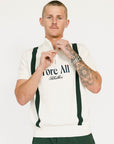 A man wearing a beige zip sweater with vertical green stripes and the text 'Fore All x Khalhon' on the chest, paired with dark green shorts.