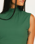 Woman wearing a green dress Manhattan Mock Neck against a white background