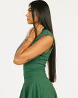 Woman wearing a green dress Manhattan Mock Neck against a white background