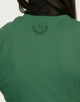 Woman wearing a green dress Manhattan Mock Neck against a white background