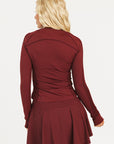 Woman wearing a burgundy outfit with a logo on a white background