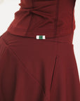 Woman wearing a burgundy Marie Long Sleeve with a logo on a white background