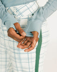 Woman wearing a smoke blue Marie long-sleeve top and plaid pants on a white background