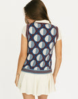 Woman wearing a patterned Yale Sweater Vest over a white shirt and skirt on a white background