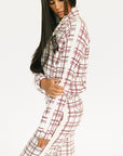 Woman wearing a merlot and white plaid Lyla Jacket on a plain background