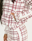 Woman wearing a merlot and white plaid Lyla Jacket on a plain background