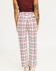 Person wearing red plaid Fore All Sloan Pants on a white background. Featuring a double snap closure and side seam pockets.
