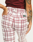 Person wearing red plaid Fore All Sloan Pants on a white background. Featuring a double snap closure and side seam pockets.