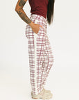 Person wearing red plaid Fore All Sloan Pants on a white background. Featuring a double snap closure and side seam pockets.