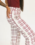 Person wearing red plaid Fore All Sloan Pants on a white background. Featuring a double snap closure and side seam pockets.