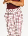 Person wearing red plaid Fore All Sloan Pants on a white background. Featuring a double snap closure and side seam pockets.