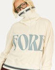 Person wearing a cream hoodie with 'FORE' text and maroon shorts on a white background