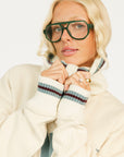 Person wearing a cream hoodie with 'FORE' text and maroon shorts on a white background