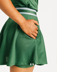 Person wearing a green Brooklyn skirt and polo on a white background. Featuring built in shorties and a Fore All logo on the front.