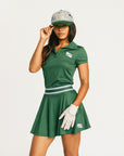 Person wearing a green Brooklyn skirt and polo on a white background. Featuring built in shorties and a Fore All logo on the front.