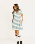 Woman wearing a blue and white striped Poppy Dress with text on a white background