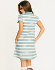 Woman wearing a blue and white striped Poppy Dress with text on a white background
