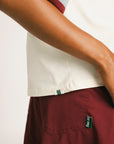 Woman wearing an angora Fore All Dillon Polo with various logos on a plain background