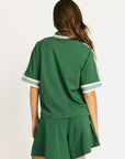 Woman wearing a green Fore All Dillon Polo with visible branding on a plain background