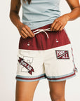 Person wearing the Fore All Fletcher short in merlot with branding on a plain background